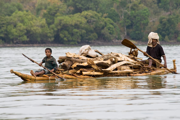 אב ובנו מובילים עצים בסירת במבוק על אגם טאנה