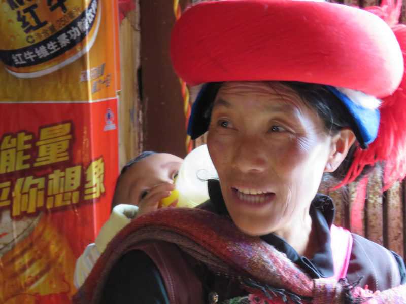 סבתא טיבטית נושאת את נכדה כדי שבתה תוכל לצאת לפרנס