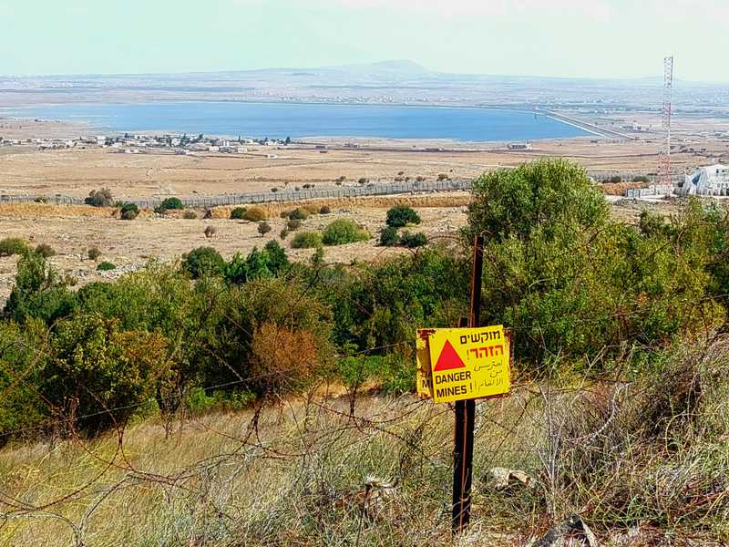 אינספור שדות מוקשים מוקפים בגדרות ומסומנים במשולשי אזהרה צהובים.