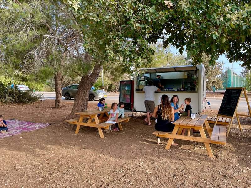 מוסנזון פוד טראק. סביבה נעימה ומזמינה עם מחצלות ושולחנות בין העצים | צילום: פז בן דוד