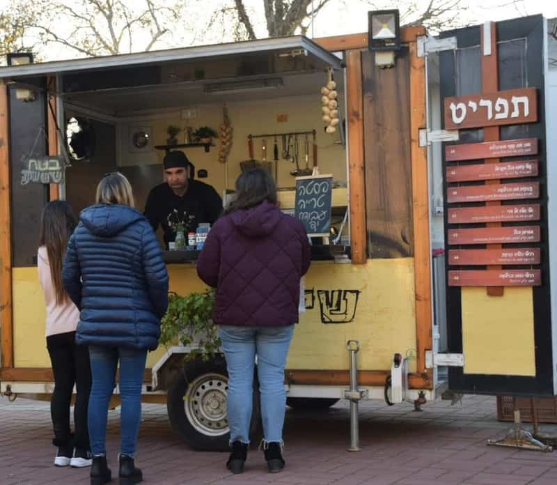 נועם שירי במשאית הפסטות שלו בסביבה הפסטורלית של קיבוץ דפנה