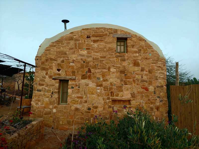 קיר ביתה פונה אל בית הקפה. נדמה שכל אבן נבחרה בקפידה והתחברה בטיט ואהבה אל האבנים שלצידה. כך גם הכינה מרק שעועית שחורה טעים להפליא, פאי תפוחים ללקק את האצבעות, וכוס יין חם בערב קריר שמשלים את התמונה