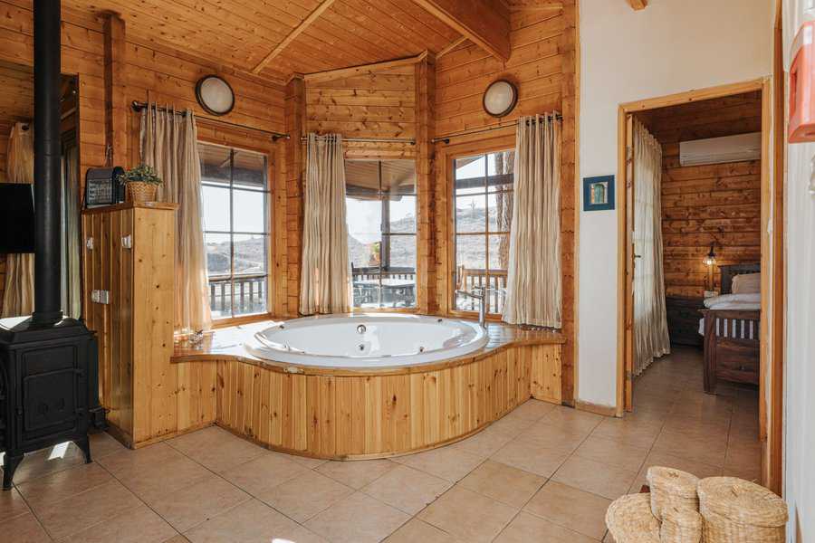 בקתה בקיבוץ אורטל. אח, ג'קוזי ונוף | צילום:אדריאן סֶבָּל