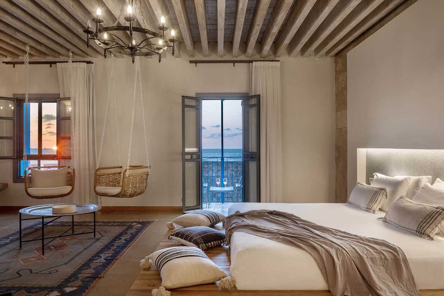 חדר עם נוף לים ונדנדות שתלויות מהתקרה בעכותיקה | צילום: איה עזרן