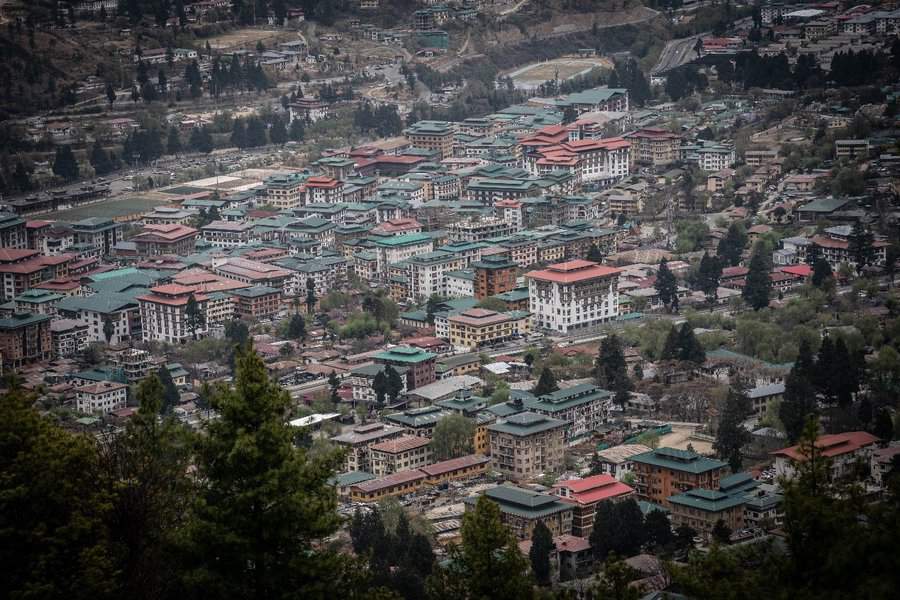 טימפו, בירת בהוטן. המבנים עם הגג הירוק הם מבנים ממשלתיים – משרדים ובתי מלון. המבנים בעלי הגגות האדומים – הם מבנים פרטיים. על פי החוק לא ניתן לבנות מעל לשש קומות ויש לשמור על צביון האדריכלות המסורתי