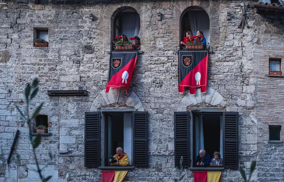 מהחלונות צופים משתתפים על המיסה. דגלים מייצגים את הקבוצות השונות