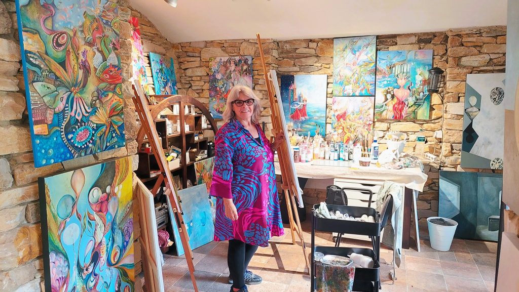 קארי היא אמנית רב תחומית. הסטודיו שלה בנוי בתוך טרסה ומתפקע משלל ציורים פסיכודליים שהיא מציירת תחת ההשראה של האחוזה