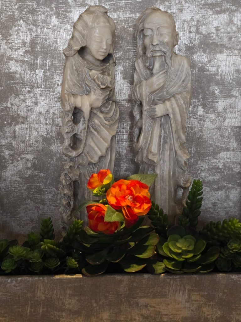 נורית שבח. צילום יפה לא חייבים לתפוס, אפשר גם ליצור. בצילום של נורית, שתי הדמויות האפורות שמביטות מטה אל הפרח שבולט באדום, יוצרות לנו סצנה מעניינת יש מאין