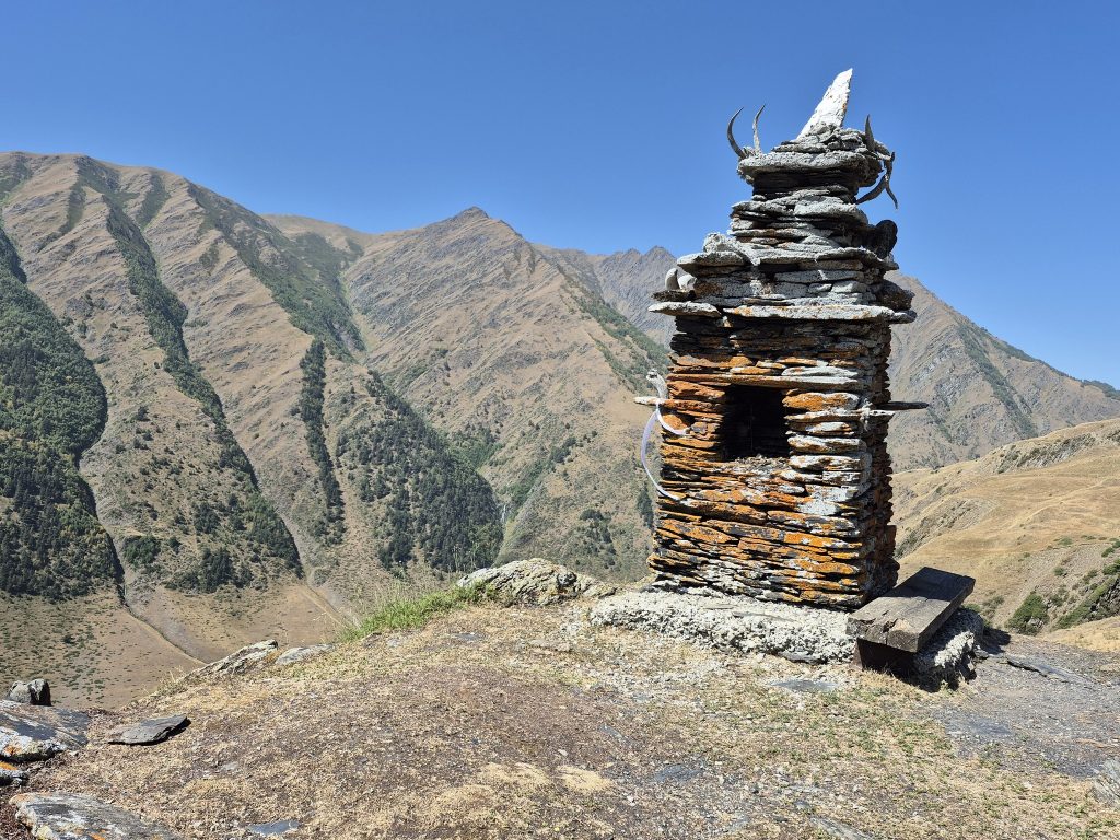 הם עברו והצטלבו על האוכף ליד מזבח הכפר המקושט בשלל קרניים, קרני אייל מסועפות, קרני צבאים, קרני עיזי בר קטנות וקרני כבשי בר עצומות