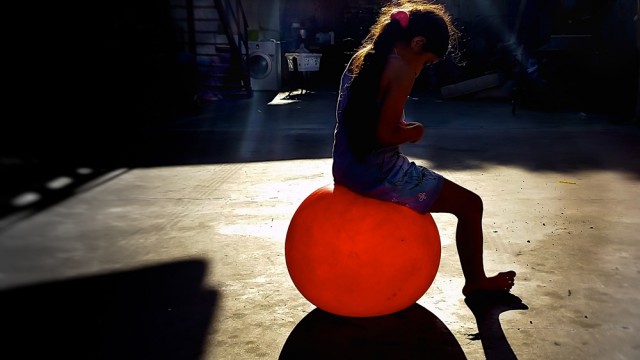 ילדה יושבת על בלון אדום, צילום: אליעזר יערי