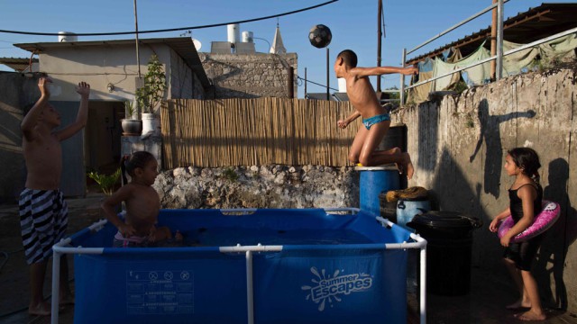 נכדיו של שייח' מוסלמי חשוב משתעשעים בבריכה על רקע האופייני לרמלה העתיקה, צילום: תלי עידן